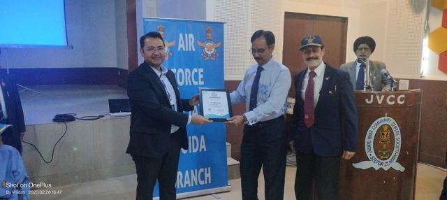 A plaque being presented to a team member by association office bearers beside a branch banner