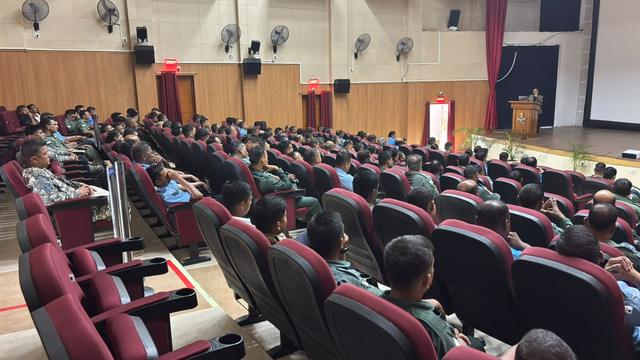 Rows of Air Force personnel seated in an auditorium during a session
