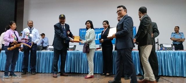 Office bearers presenting a certificate and memento to team members on stage