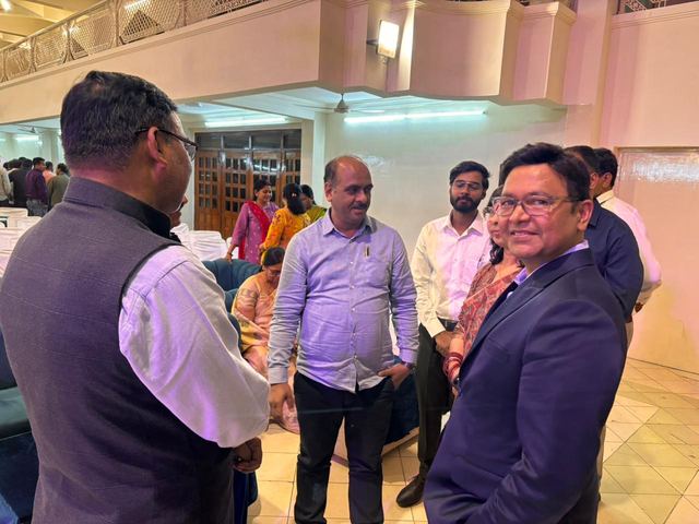 Team members talking with attendees among the seating in a community hall