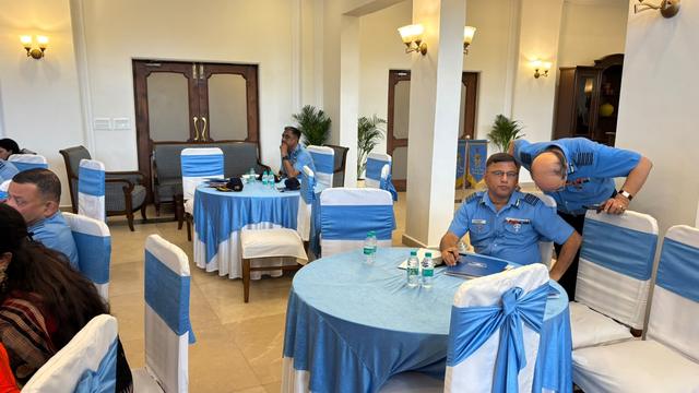 Officers seated at tables in conversation during a seminar break
