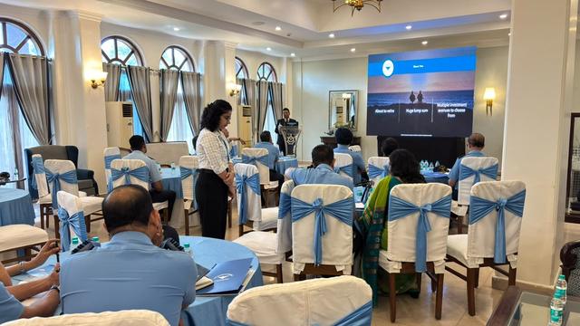 A team member presenting to seated officers with a screen in the background