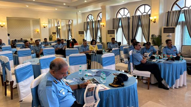 An officer reading printed investor material at a seminar table