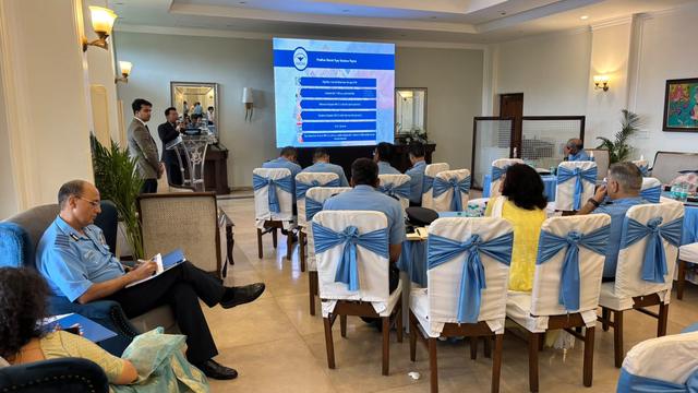 Session on senior citizen pension schemes with audience seated at draped chairs